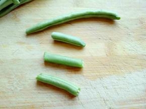 刀豆去根去尖，也就是把头和尾掰掉。把去掉两端么刀豆用手掰开，一根刀豆掰了3节。如图(可以根据个人喜欢)依次完成，洗干净备用。