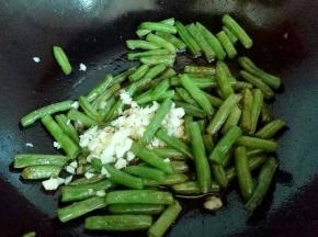 加入切碎的蒜末继续大火煸炒，把刀豆炒熟。