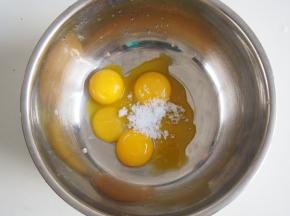 蛋黄中加入白糖，打发至颜色变浅，糖基本溶化，并且蛋黄液变得浓稠有光泽。