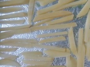 烤盘铺锡纸，上面刷油把拌好的薯条铺在烤盘上