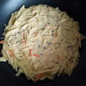 平底锅加入少量油，油温达到时盛一勺面糊倒入锅中，摊平整。