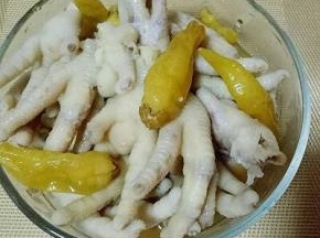 煮好的鸡爪凉透后，放入玻璃碗中，倒入泡椒，可以适当加一点凉水，盖上盖子放入冰箱冷藏泡一夜。会很入味哦。