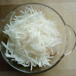 白萝卜去皮，切丝，放入玻璃容器中，用盐腌制20分钟。