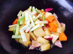 当土豆煸炒至微黄色时倒入芹菜煸炒