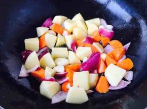 先倒入胡萝卜块，煸炒5分钟，然后倒入土豆块煸炒。