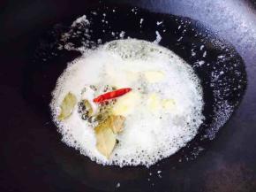 在炖牛腩肉期间我们还要炒制一碗红面酱。
锅温热，放入60g黄油，放入2个干辣椒和2片香叶煸炒出香味。