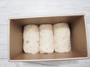 将卷好的面团放入吐司盒中，发酵至8分满。烤箱预热至180度，盖上盖子放入烤箱中下层，35分钟左右即可