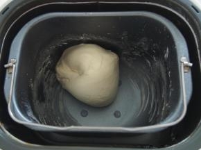 加入清水，开启揉面程序，揉成光滑面团后加入黄油，揉至出膜