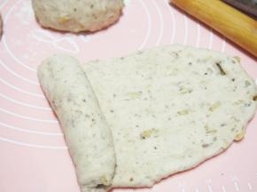 取其中一块面团擀成牛舌状，从一侧卷起