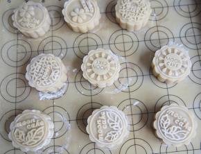 月饼进烤箱前轻轻喷上一层水，140度烘烤10分钟左右定型后取出，刷上一层蛋液，继续烘烤35分钟左右看月饼上色即可