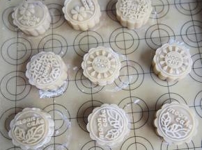 月饼进烤箱前轻轻喷上一层水，140度烘烤10分钟左右定型后取出，刷上一层蛋液，继续烘烤35分钟左右看月饼上色即可