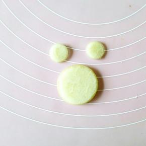 首先取一块西瓜皮，去掉红色的和绿色的部分，用圆形模具分别刻出青蛙的脸部和耳朵。