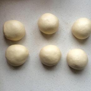 4、面团用擀面杖进行排气，称重平均分割6份，滚圆，加保鲜膜静置15分钟