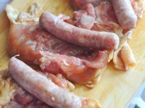 鸡肉平铺，把香肠放在上面。