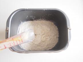 将面粉放入面包机桶中，在一个角落加入盐、糖和酵母