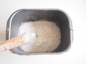 将面粉放入面包机桶中，在一个角落加入盐、糖和酵母