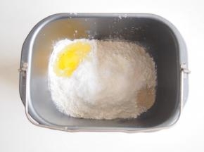 在面包机桶的对角放入鸡蛋，加入清水，揉成光滑面团