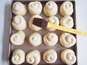 烤盘底放入融化的黄油，高度为面包的1/6左右即可。将底部蘸了芝麻的面包胚摆放整齐，中间压一下防止发酵时鼓出。继续发酵至1.5倍大后表面刷一层融化的黄油。烤箱预热至170度，中层上下火，20分钟左右即可。出炉后趁热刷一层蜂蜜水（蜂蜜：清水=1：1）即可。