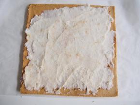 将蛋糕翻过来，抹上一层山药泥，轻轻卷起，用油纸包住，放入冰箱冷藏定型即可