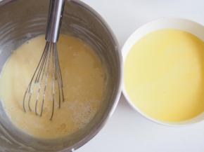 将加热好的牛奶分几次倒入面糊中，每次都充分搅拌均匀