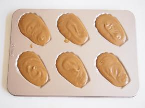 模具上刷一层黄油，将面糊装入裱花袋，挤入模具