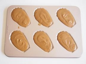 模具上刷一层黄油，将面糊装入裱花袋，挤入模具