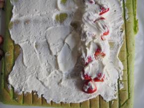 将淡奶油打发，抹在蛋糕的正面，铺上草莓，卷起后放入冰箱冷藏半小时定型切片即可