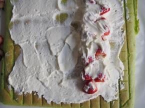 将淡奶油打发，抹在蛋糕的正面，铺上草莓，卷起后放入冰箱冷藏半小时定型切片即可