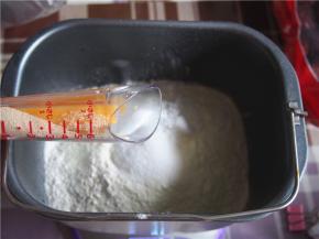 在面包桶的一个角落里放入酵母