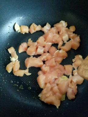 锅中放入适量油，加入蒜和姜炒香，加入鸡胸肉丁煸炒