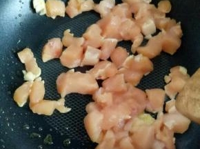 锅中放入适量油，加入蒜和姜炒香，加入鸡胸肉丁煸炒