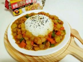 把一碗米饭用铲子压实，倒扣在盘子中间，米饭上撒上熟黑芝麻，把咖喱鸡盛一勺以撒倒的方式装满盘子。