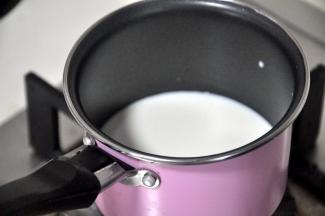 将牛奶倒入锅中煮沸。