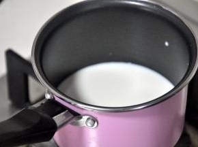 将牛奶倒入锅中煮沸。