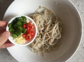 倒入切碎的蒜末、切段的小米辣和青椒