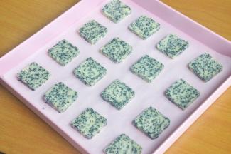 将冷冻好的饼干团，切成0.7cm左右的厚片，放入烤盘中。