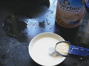 取6勺嘉宝燕麦米粉放入冲泡好的配方奶中搅拌均匀