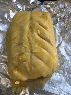 取出，酥皮用锋利的刀割出纹路，抹上蛋黄液