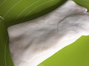 然后两面对折像叠被子一样，继续擀薄，这个步骤重复三次，最后擀成2mm厚的面皮后用用保鲜膜包住放冰箱冷藏半小时