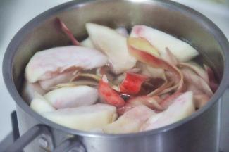 小锅中加入水和白砂糖加热融化，随后放入桃子和果皮。