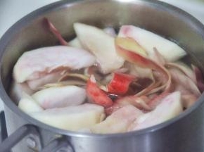 小锅中加入水和白砂糖加热融化，随后放入桃子和果皮。