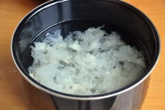 将银耳黄色的根部去掉，撕成小朵，加入适量水。