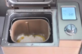 面包桶内依次加入水、牛奶，倒入面粉，尽量让面粉覆盖整个水面，靠近面包桶一角放盐、另一角放糖。在面粉上挖个坑，把酵母放入小坑内，确保酵母不与水和盐接触，倒入橄榄油，面包桶放入到面包机内，顺时针旋转，卡紧面包桶。选择和面程度，揉面20分钟，启动程序。