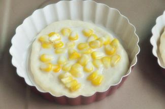 将玉米和炼乳混合，均匀的抹在披萨底上。