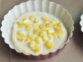 将玉米和炼乳混合，均匀的抹在披萨底上。