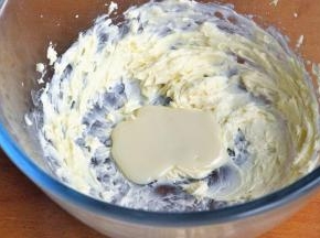 倒入一半的炼奶，让蛋清与黄油充分打发。