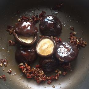 3:烤出水分后的香菇拿出来，倒进锅里随意翻几下，包裹一下汤汁