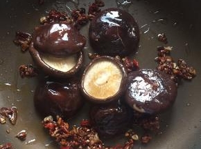 3:烤出水分后的香菇拿出来，倒进锅里随意翻几下，包裹一下汤汁
