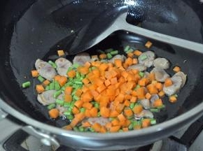 倒入胡萝卜、豇豆，翻炒2分钟。