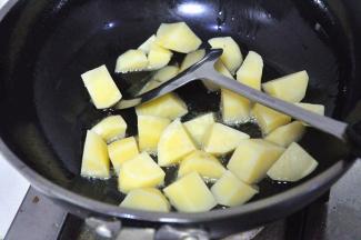 炒锅中倒油，烧至7成热，放入土豆用小火煎，一直煎到外皮变得焦黄。